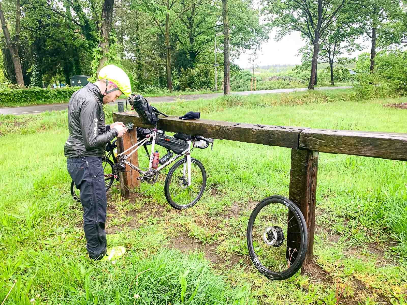 Een fiets met een lekke band wordt over een houten borstwering gehangen.