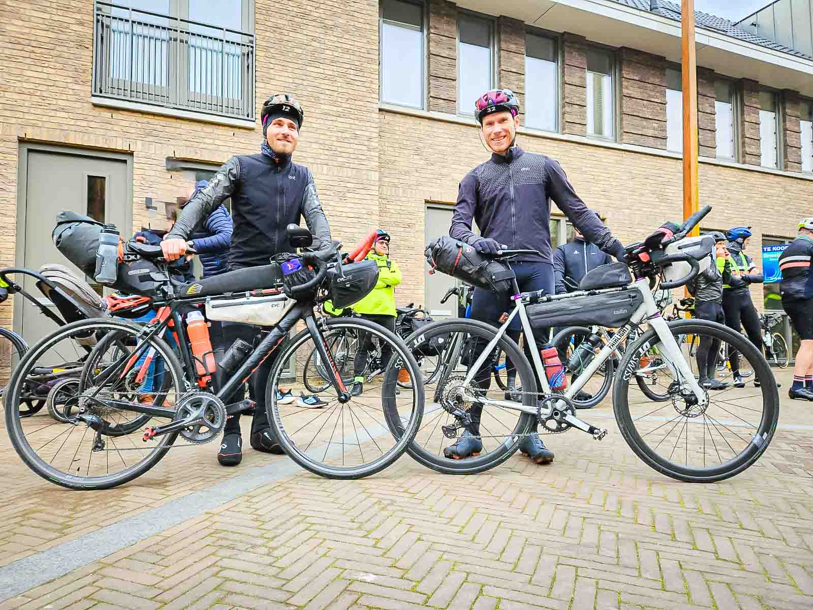 Twee deelnemers aan het utra fietsevenement Race om Nederland staan aan de start en lachen in de camera