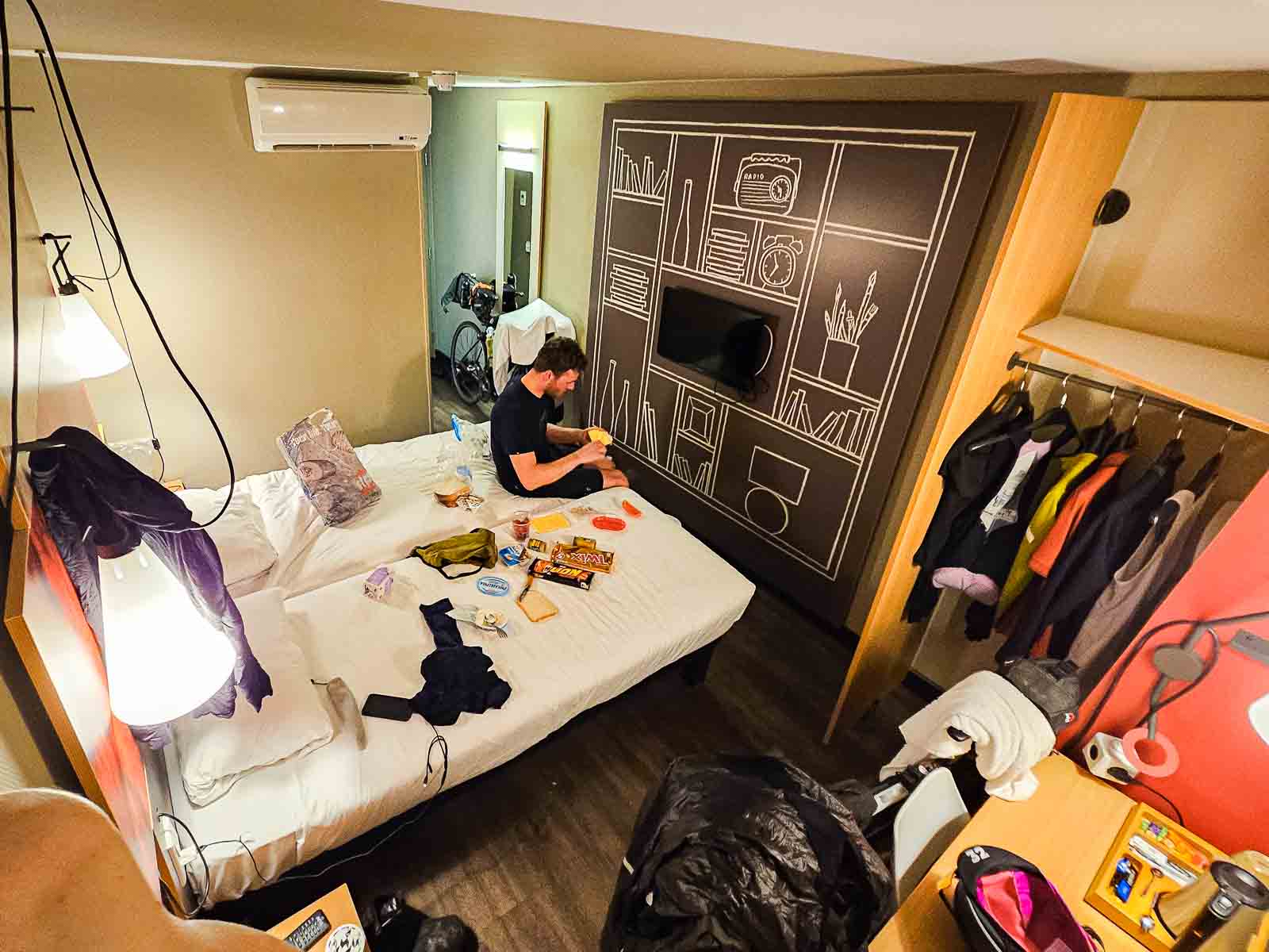Een hotelkamer van twee deelnemers aan de Race om Nederland is volgepropt met fietsen, eten en kleding