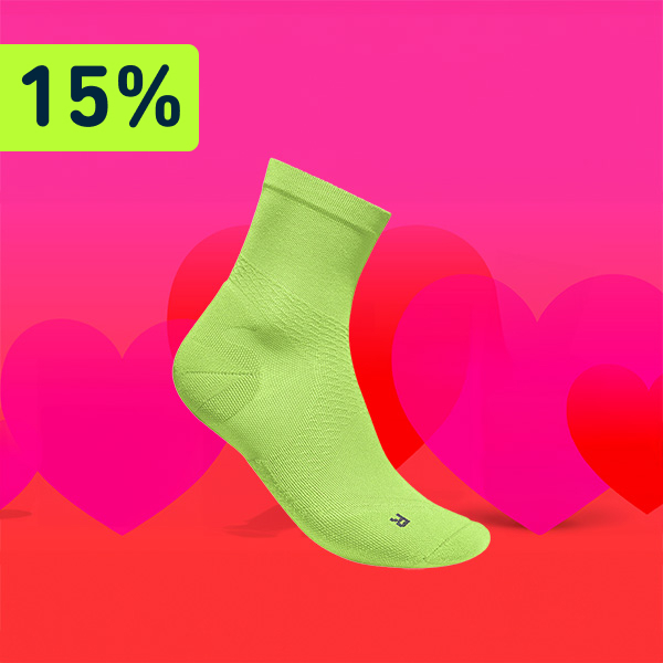 Een rode en roze achtergrond met in het midden de “Run Ultralight Mid Cut Socks”. Daarboven staat een verwijzing naar 15% korting. 