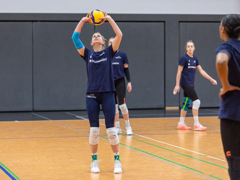 Eine Spielerin des SCC Palmberg in einer Sporthalle nimmt einen Ball an und trägt eine Ellbogen-Bandage.